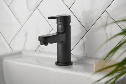 Matt black cloakroom basin mixer tap installed on white sink with marble tiles, luxury bathroom